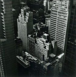 Black and white view of densely packed high-rise buildings in a city downtown area, seen from above.